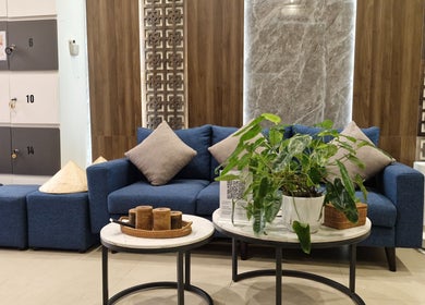 Elegant lounge area with blue sofa and plants at Nón Spa, Đà Nẵng, Đà Nẵng, VN.