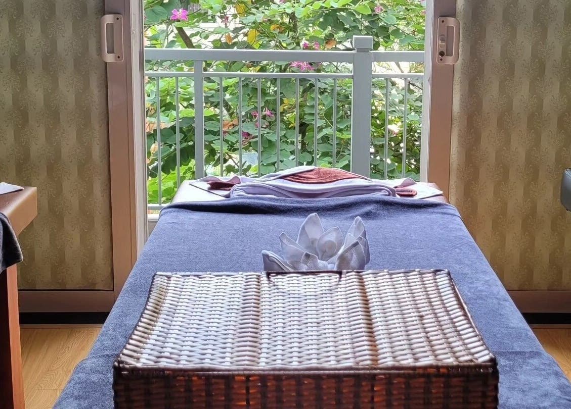 Relaxing massage table setup at Nón Spa, Đà Nẵng, Đà Nẵng, VN with a garden view and elegant decor.