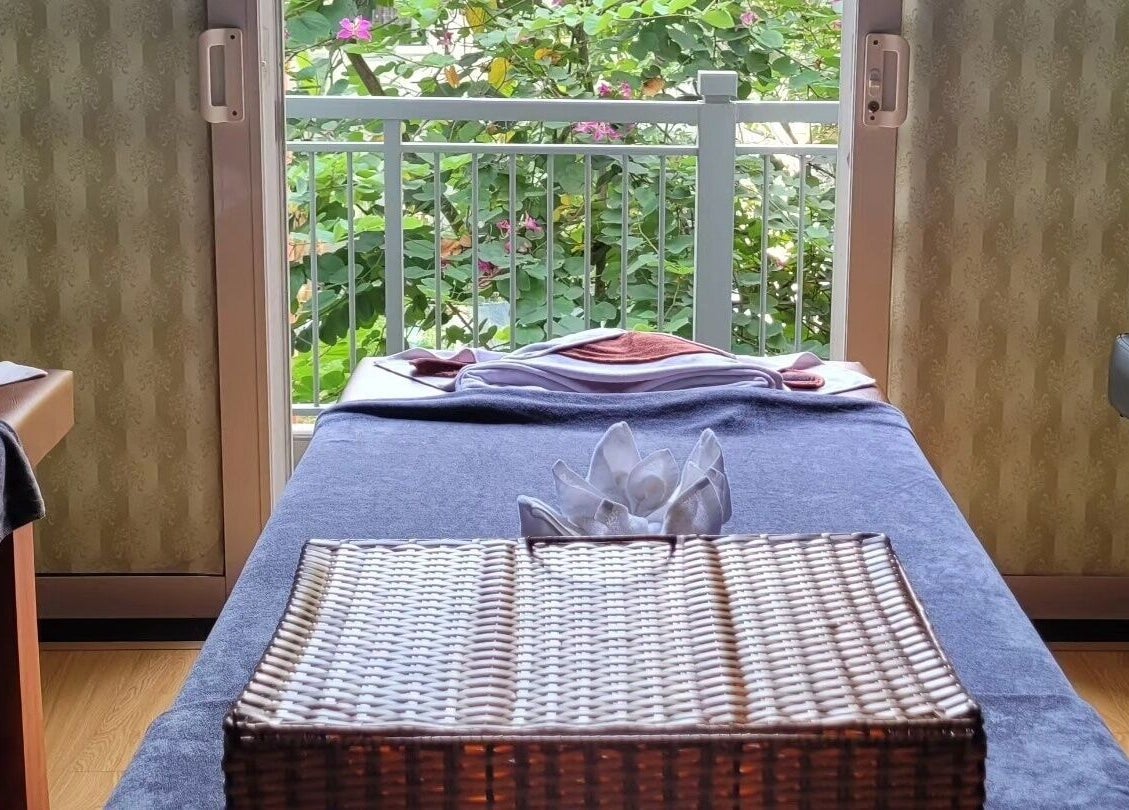 Relaxing massage table setup at Nón Spa, Đà Nẵng, Đà Nẵng, VN with a garden view and elegant decor.