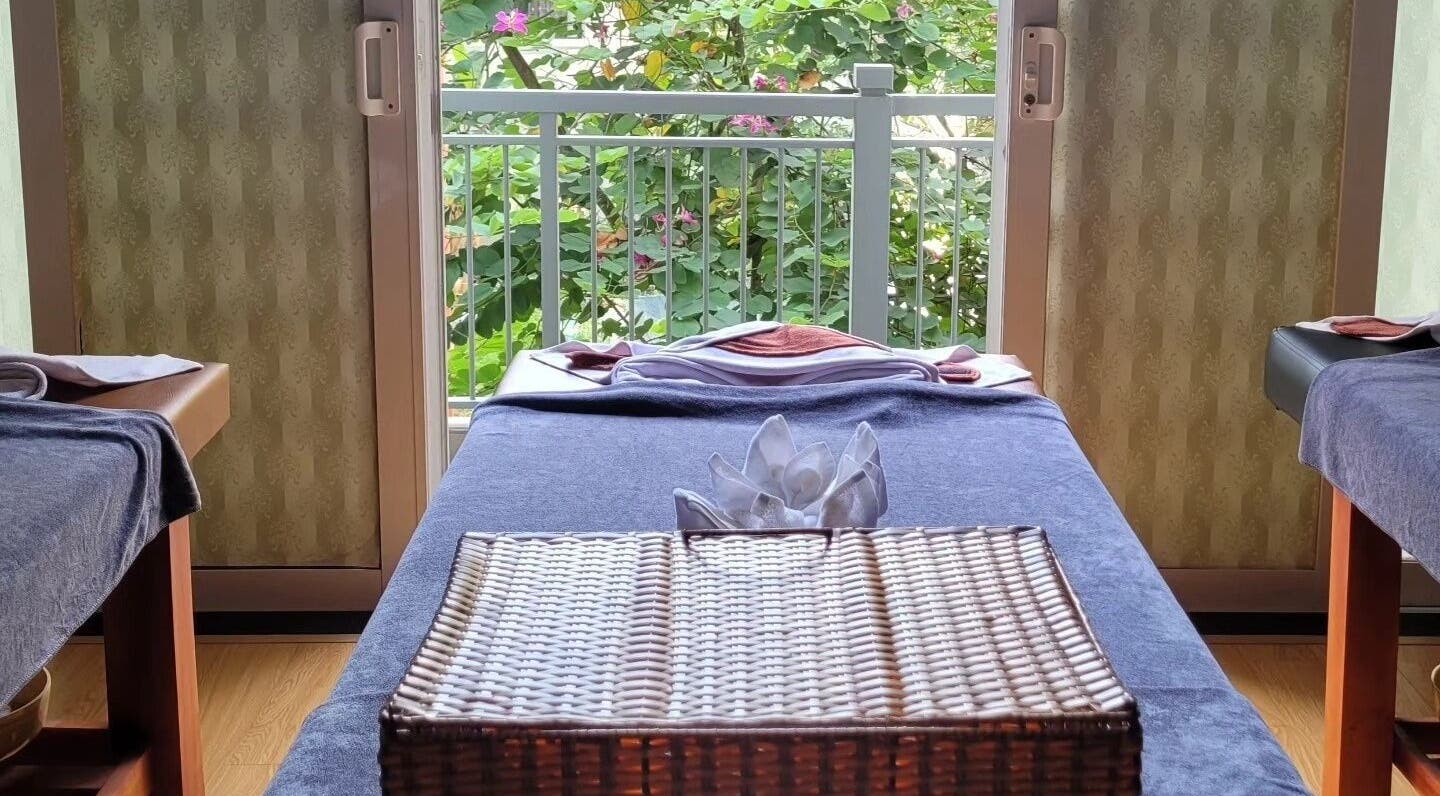 Relaxing massage table setup at Nón Spa, Đà Nẵng, Đà Nẵng, VN with a garden view and elegant decor.
