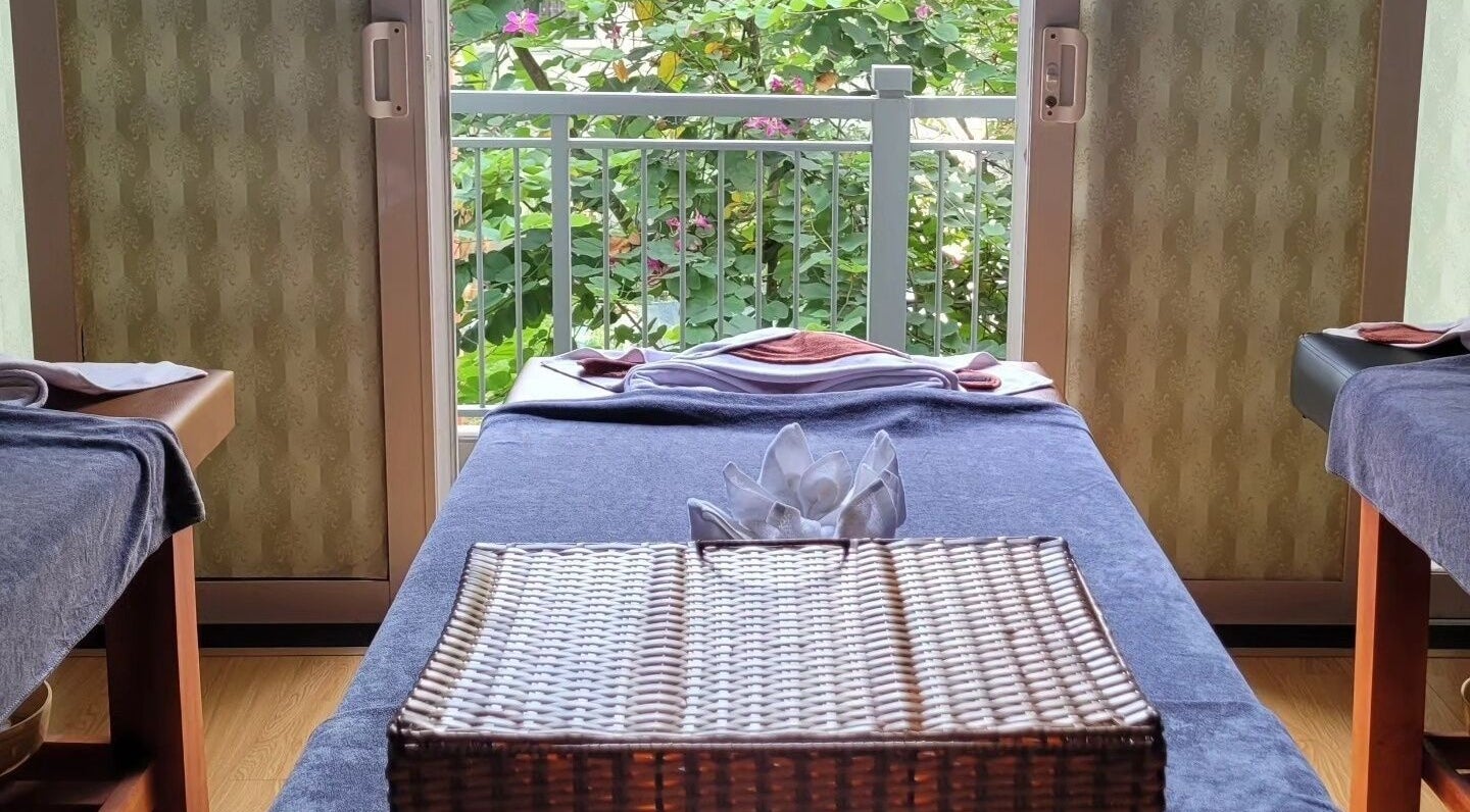 Relaxing massage table setup at Nón Spa, Đà Nẵng, Đà Nẵng, VN with a garden view and elegant decor.