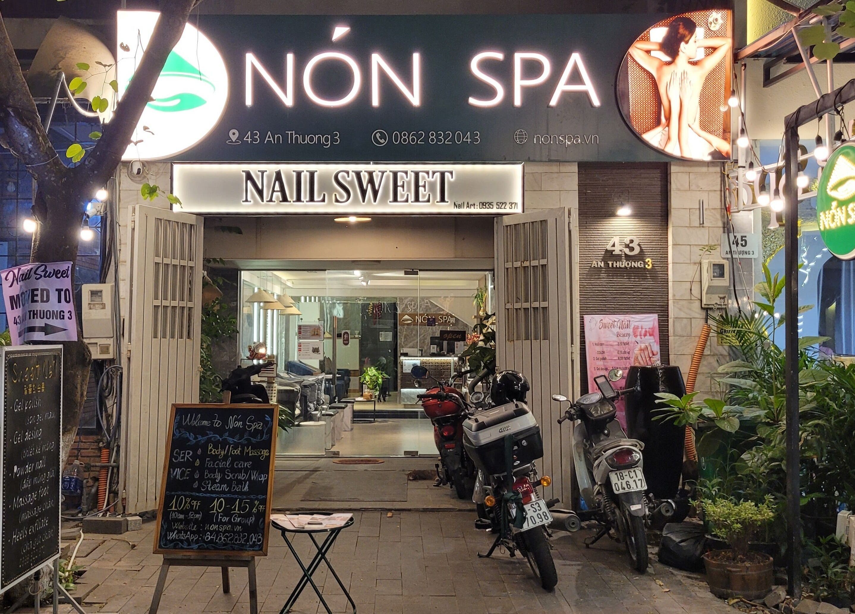 Nón Spa's inviting entrance in Đà Nẵng, Đà Nẵng, VN, highlighted by vibrant signage and greenery.