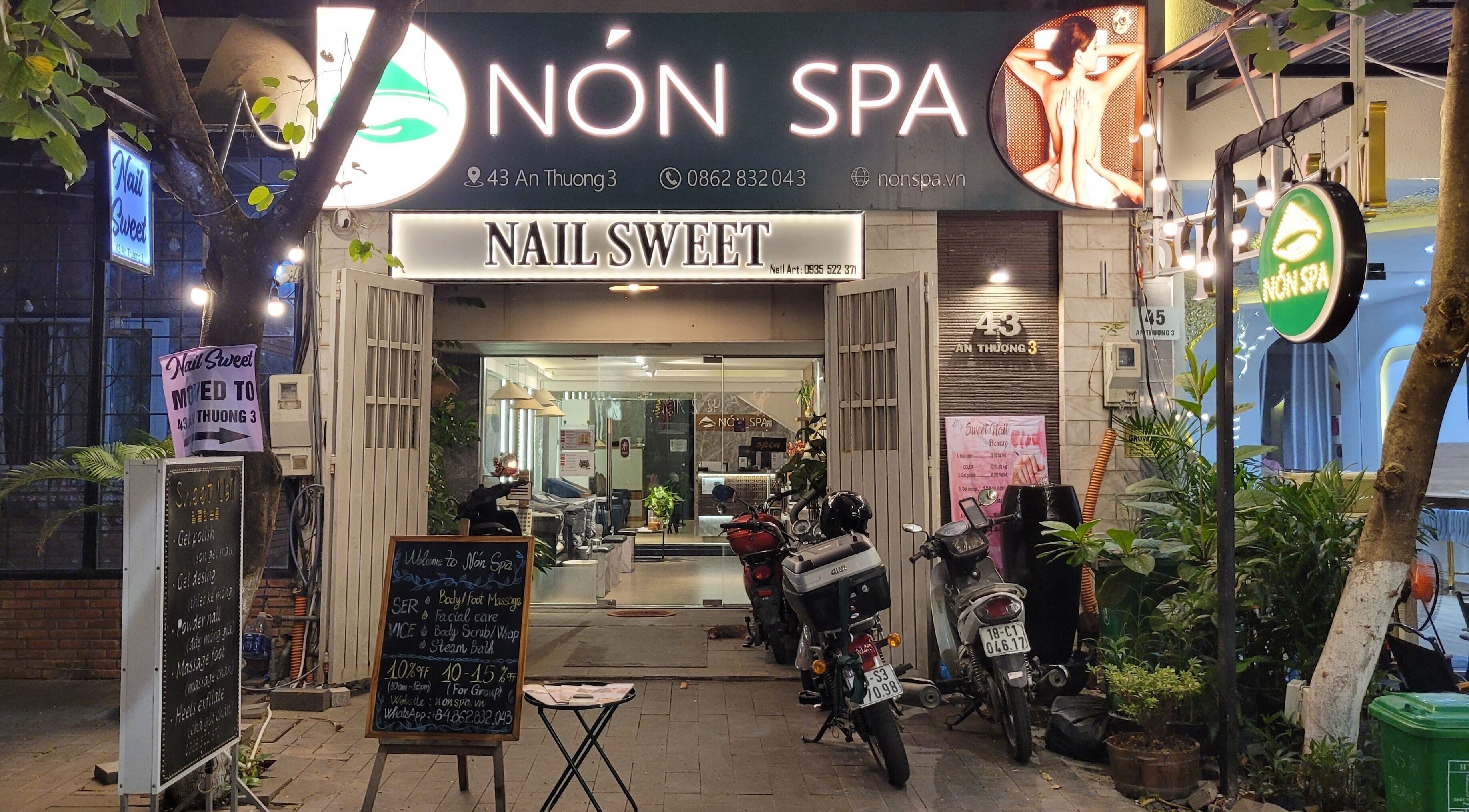 Nón Spa's inviting entrance in Đà Nẵng, Đà Nẵng, VN, highlighted by vibrant signage and greenery.
