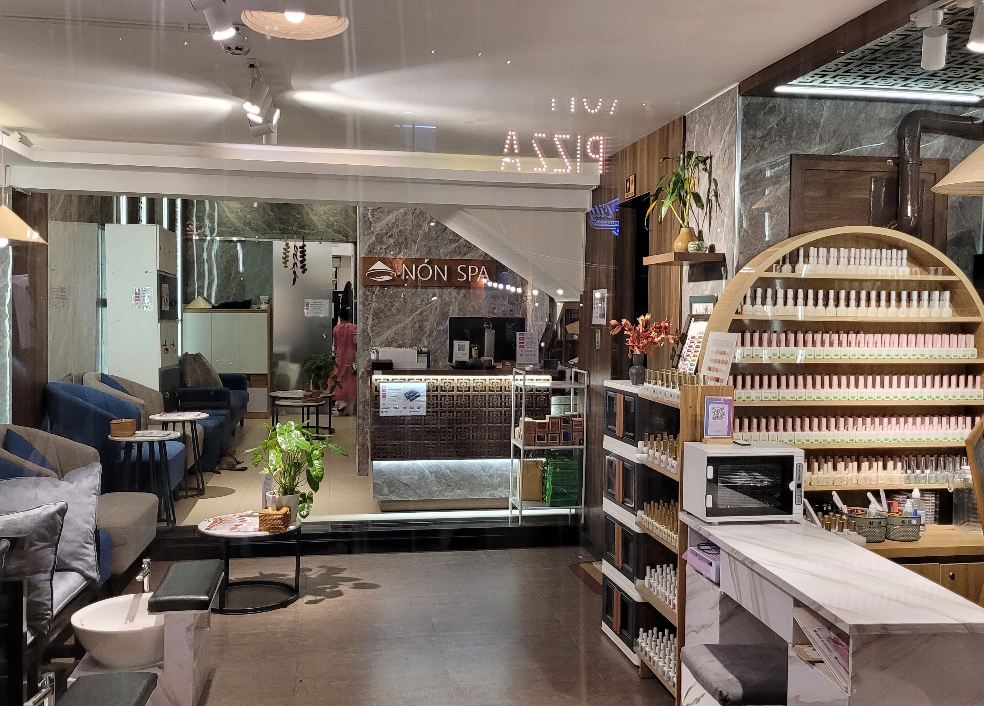 Relaxing interior of Nón Spa in Đà Nẵng, VN with cozy seating and elegant nail care display.