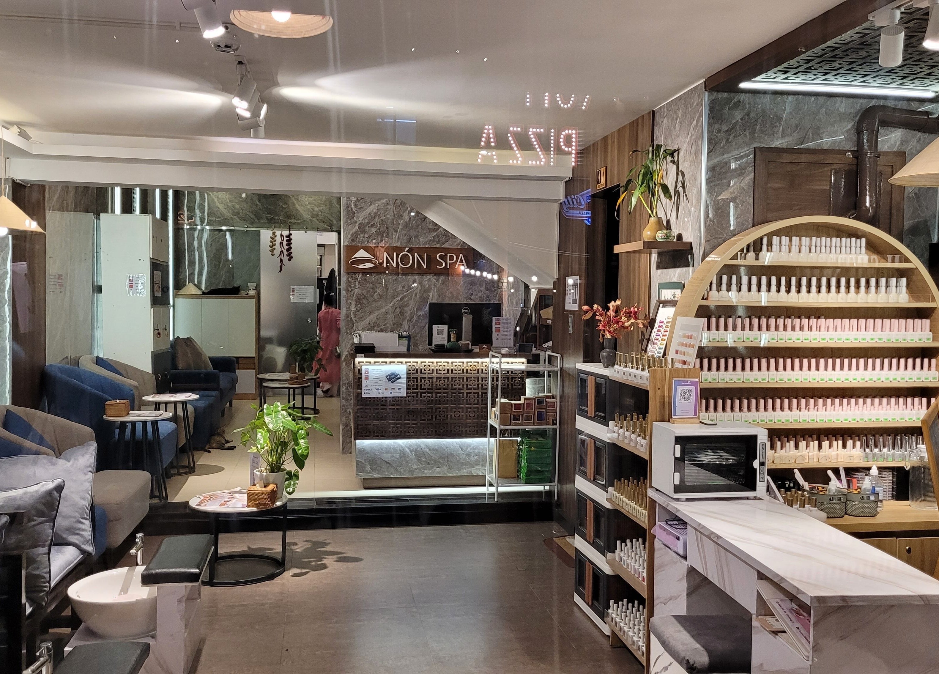 Relaxing interior of Nón Spa in Đà Nẵng, VN with cozy seating and elegant nail care display.