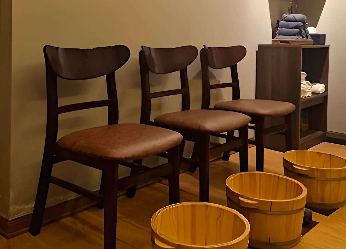 Tranquil seating area with wooden chairs and foot tubs at Nón Spa, Đà Nẵng, Đà Nẵng, VN.