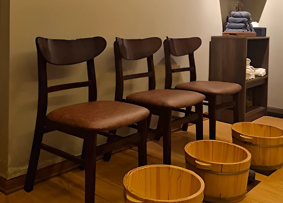 Tranquil seating area with wooden chairs and foot tubs at Nón Spa, Đà Nẵng, Đà Nẵng, VN.