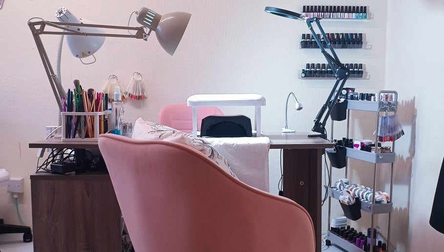 Nail salon setup at The Rainbow Studio, Southampton, GB, featuring tools, polish racks, and cozy seating.