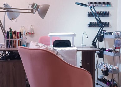 Nail salon setup at The Rainbow Studio, Southampton, GB, featuring tools, polish racks, and cozy seating.