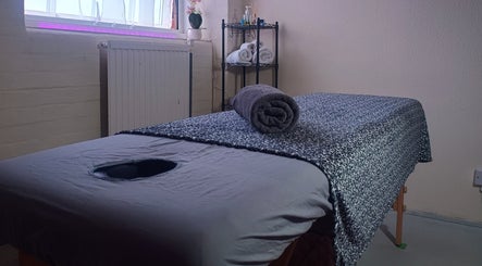 Cozy massage room at The Rainbow Studio in Southampton, GB with a neatly arranged massage table and soft lighting.