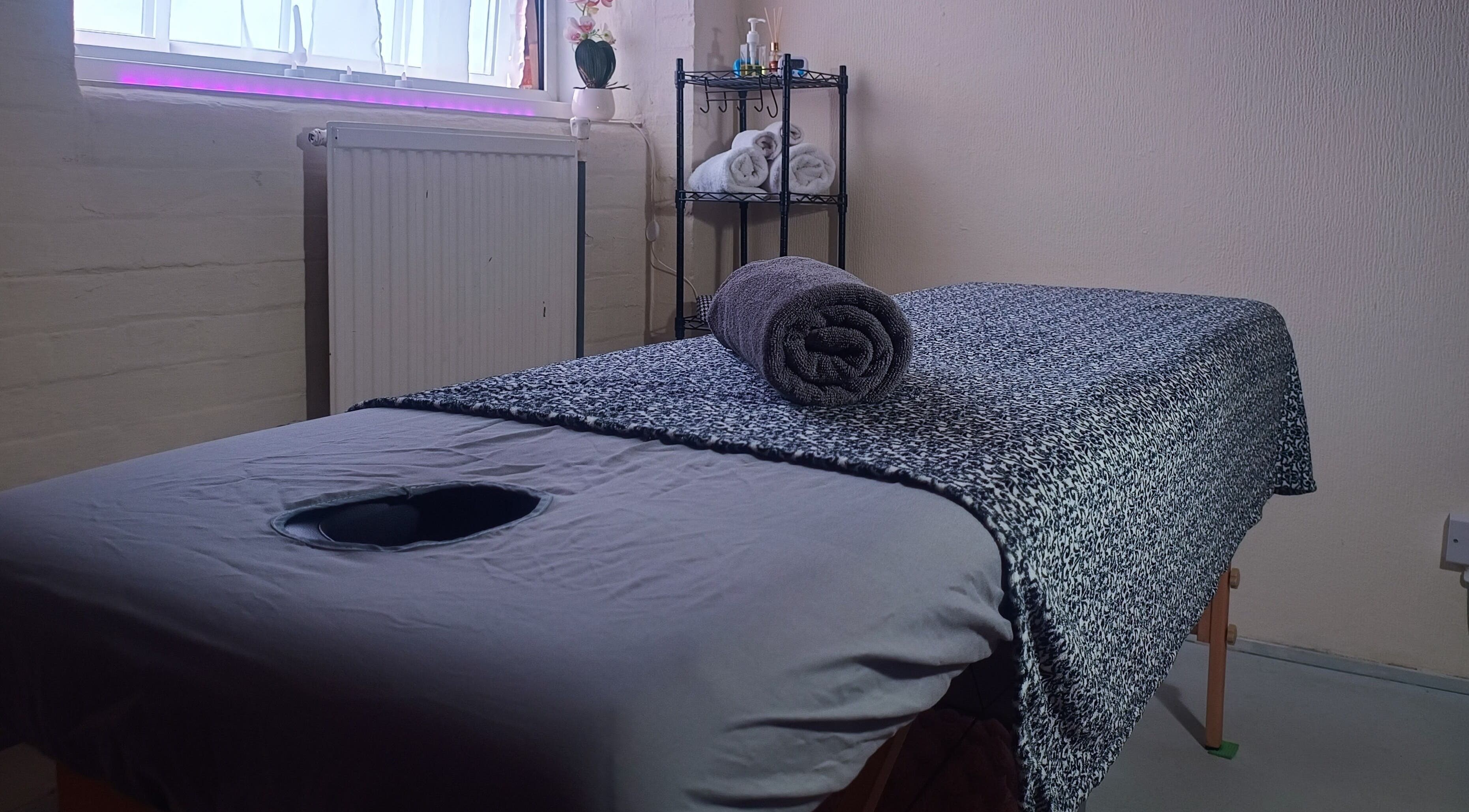 Relaxing massage table at The Rainbow Studio in Southampton, GB, with soothing decor and soft lighting.