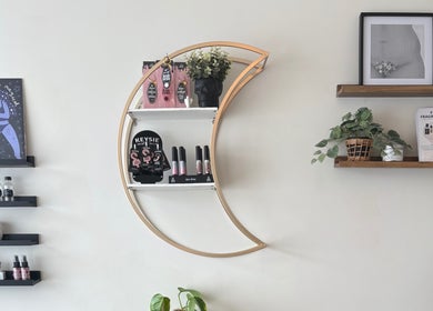 Stylish wall decor at Danie Beauty in Hillsborough, England, GB featuring moon-shaped shelf with beauty products.