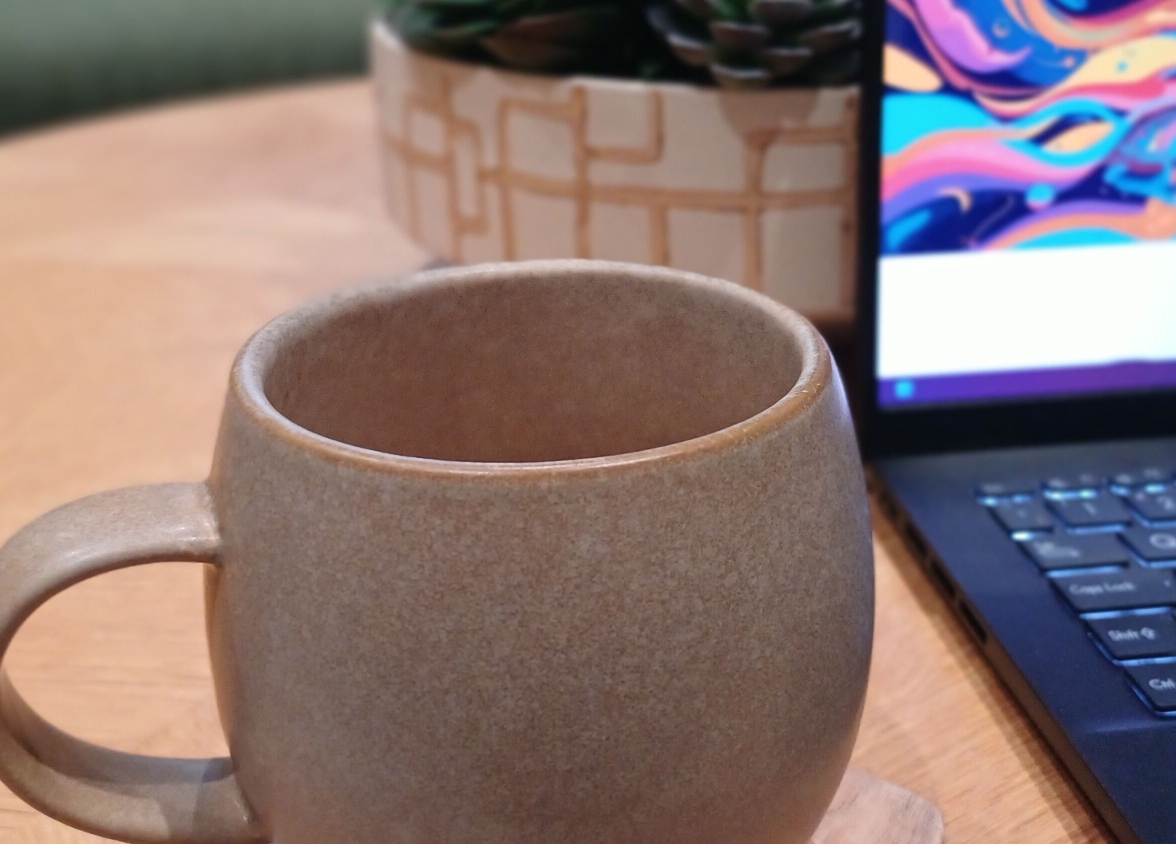 A warm ceramic mug next to a laptop at Heal With Hollie, Wirral, England, GB.