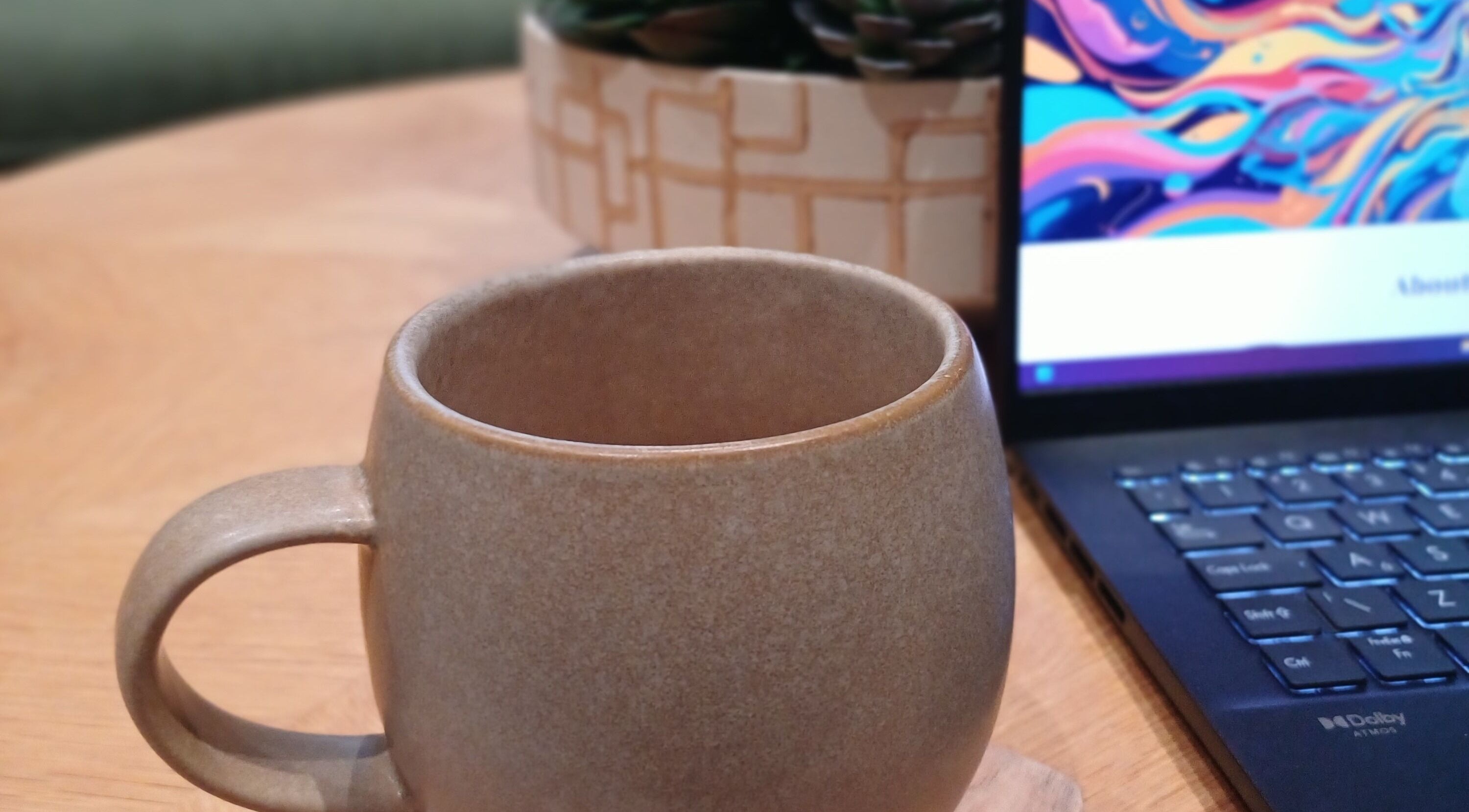 A warm ceramic mug next to a laptop at Heal With Hollie, Wirral, England, GB.
