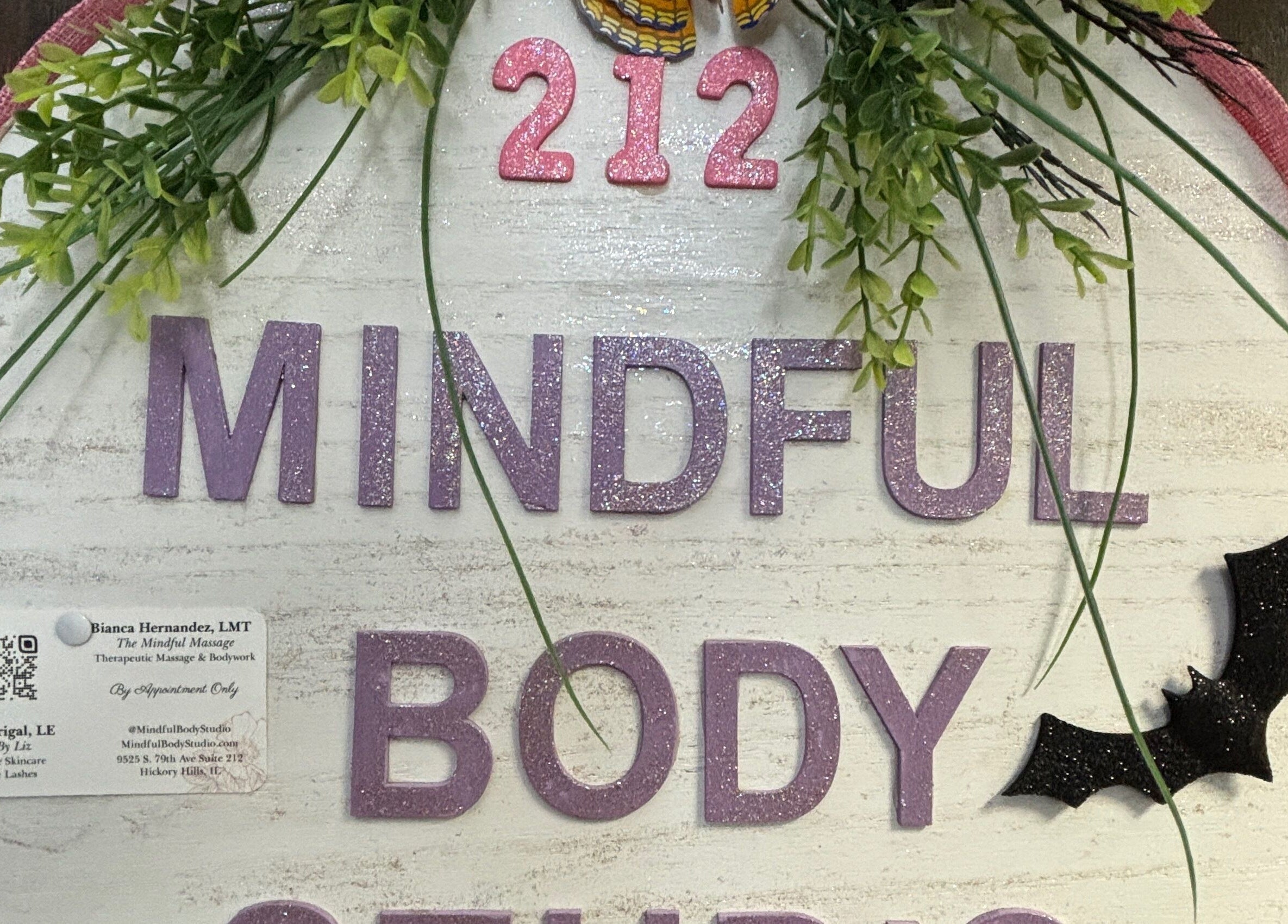 Mindful Body Studio sign adorned with greenery and decor in Hickory Hills, Illinois, US.