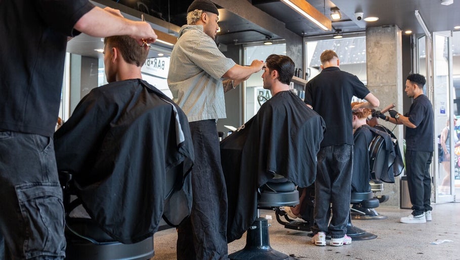 Stylists working at BAR x BAR Manly, New South Wales, AU, creating sleek haircuts for clients.