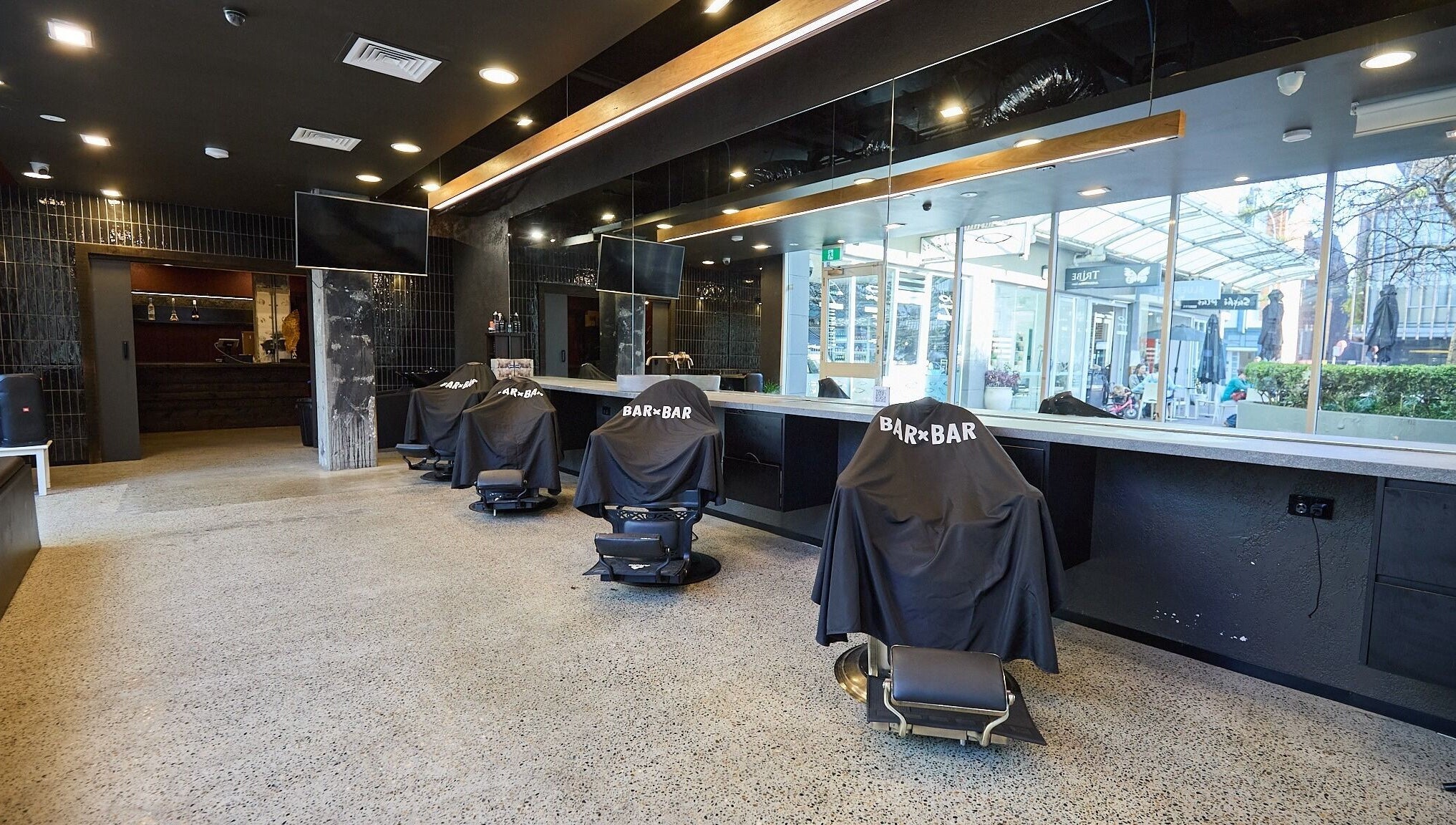 Spacious interior of BAR x BAR Manly, stylish barber chairs, Manly, New South Wales, AU.
