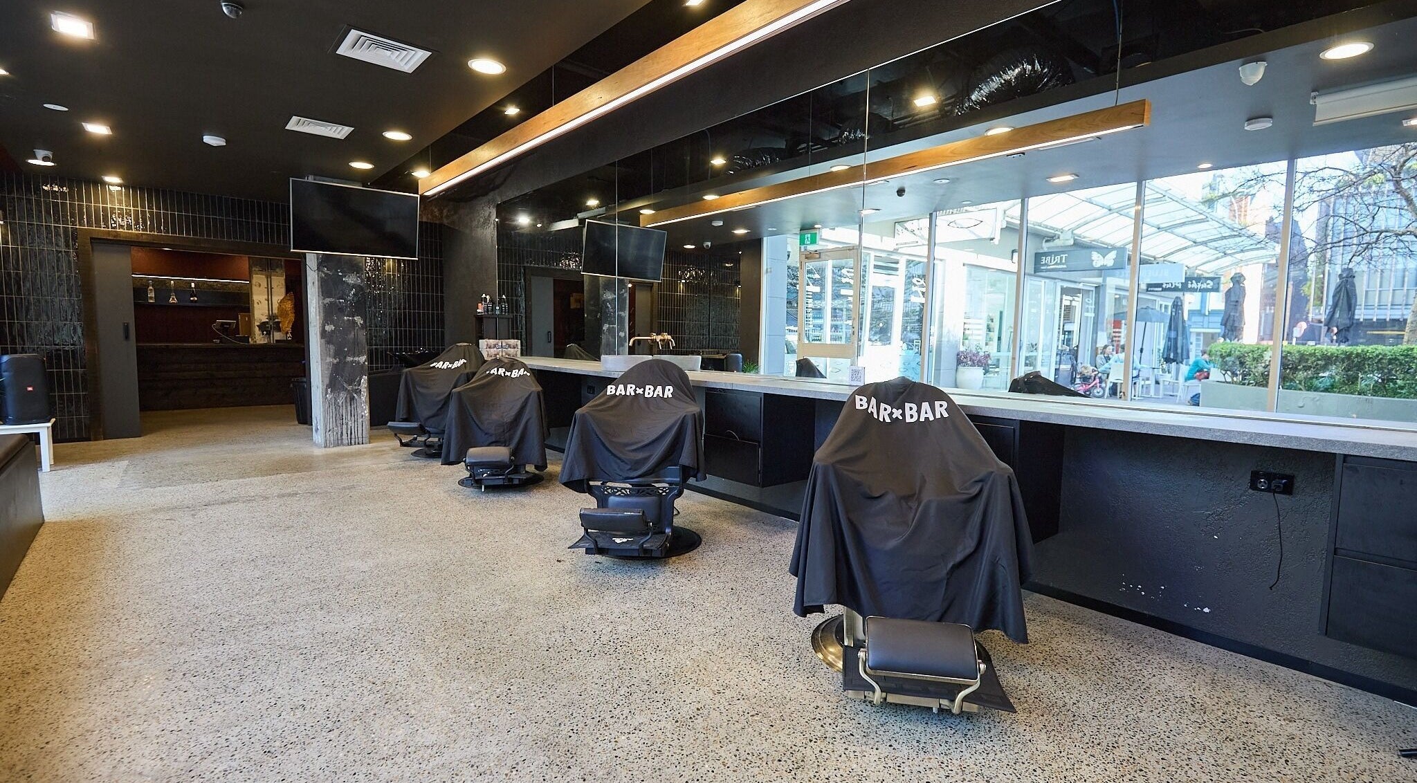 Spacious interior of BAR x BAR Manly, stylish barber chairs, Manly, New South Wales, AU.