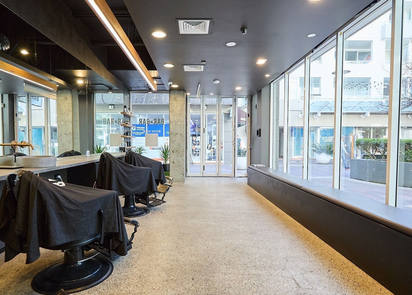 Modern salon interior at BAR x BAR Manly with sleek chairs, mirrors, and large windows in Manly, New South Wales, AU.