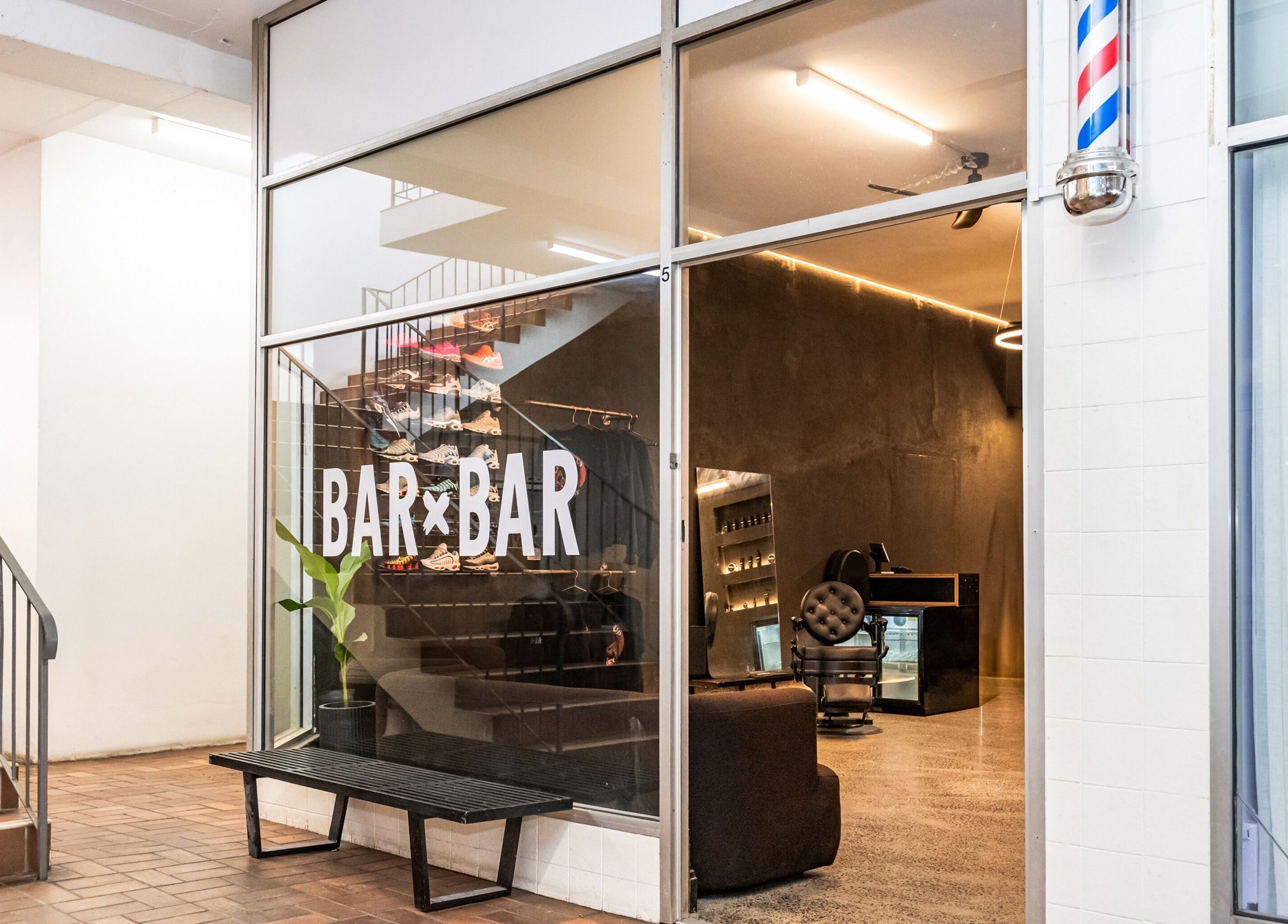 Entrance of BAR X BAR Freshwater in New South Wales, AU, featuring modern interior and barbershop symbol.