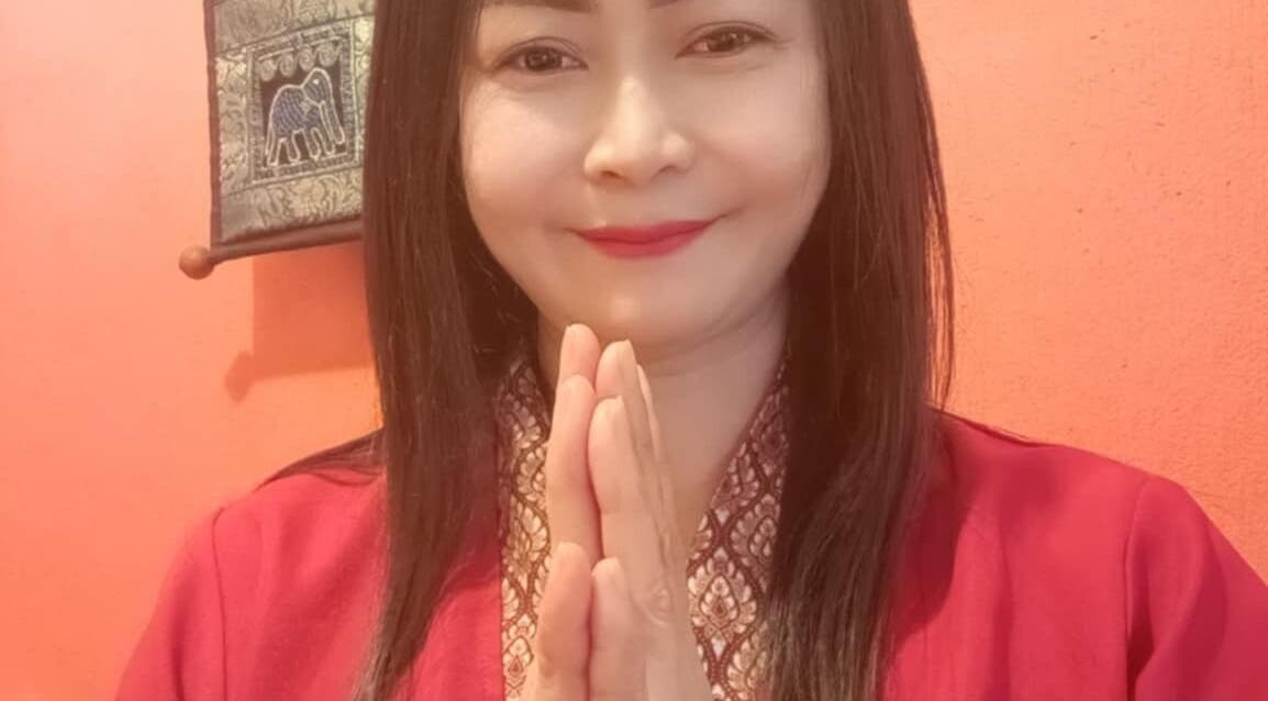 Warm greeting at Sunflower Thai Massage, Budapest, Magyar, HU with a serene smile and traditional attire.