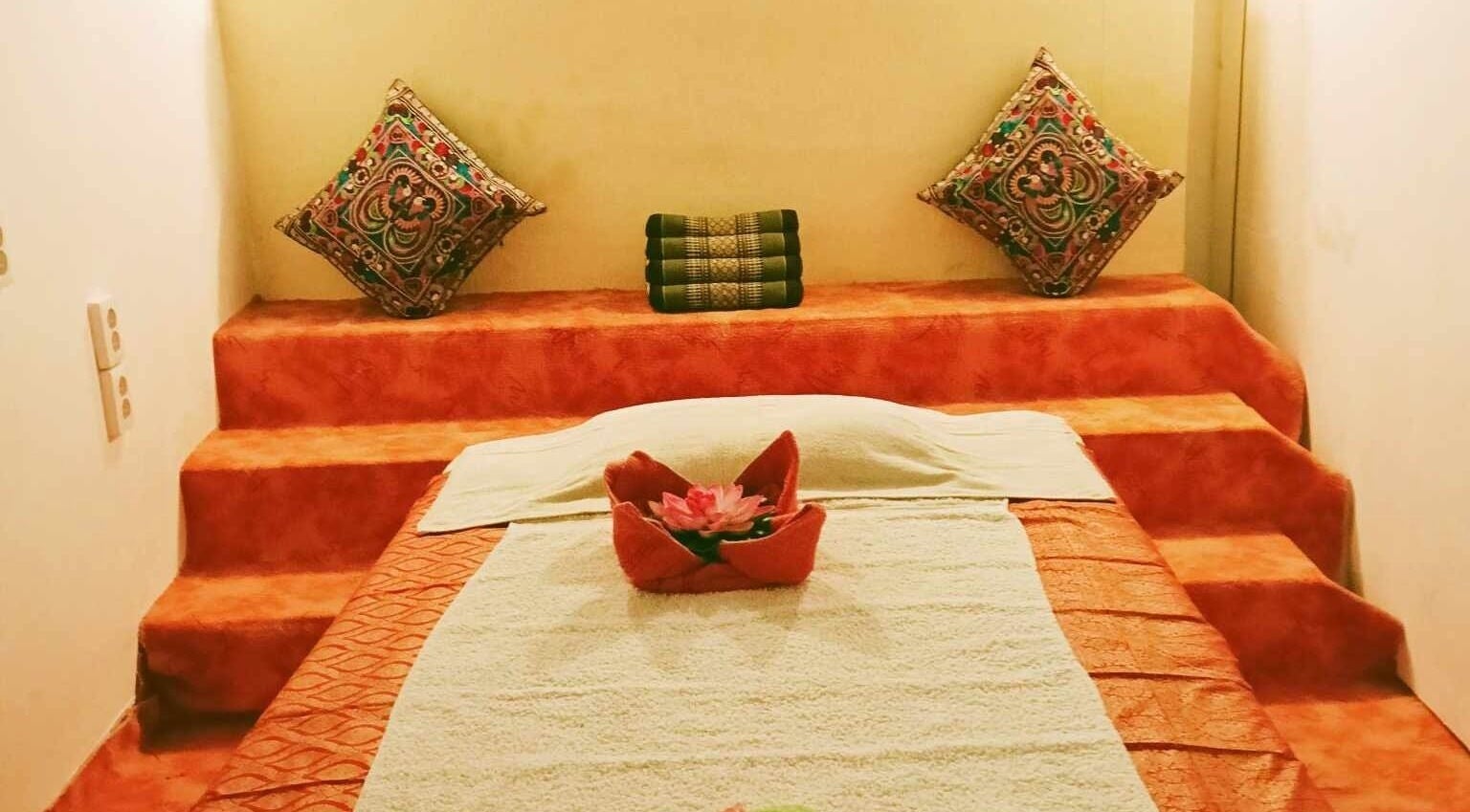 Relaxing massage bed at Sunflower Thai Massage, Budapest, Magyar, HU, adorned with colorful pillows.