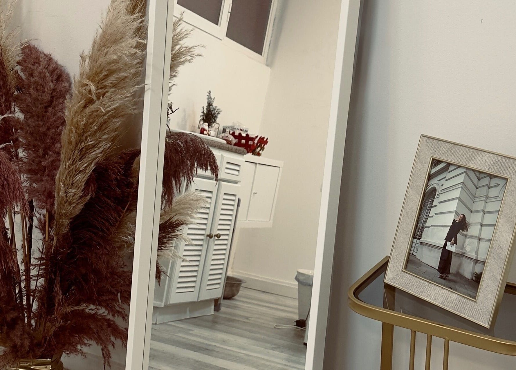 Espaço elegante em Studio IA | Gel Nails, Lisboa, PT, refletido em espelho grande com plantas decorativas.