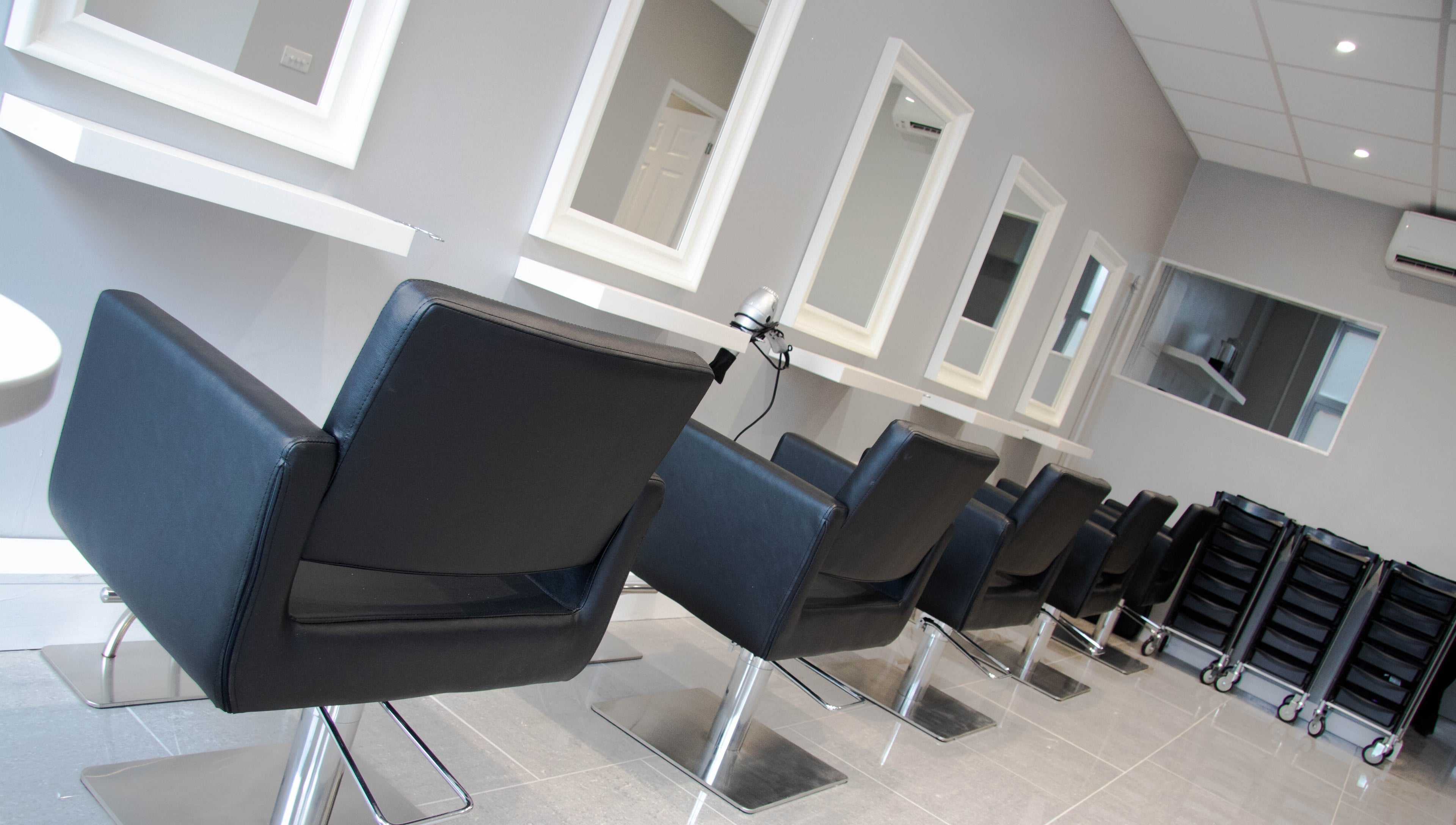 Row of stylish salon chairs at Beautique Hair and Beauty Bar, Haywards Heath, GB.