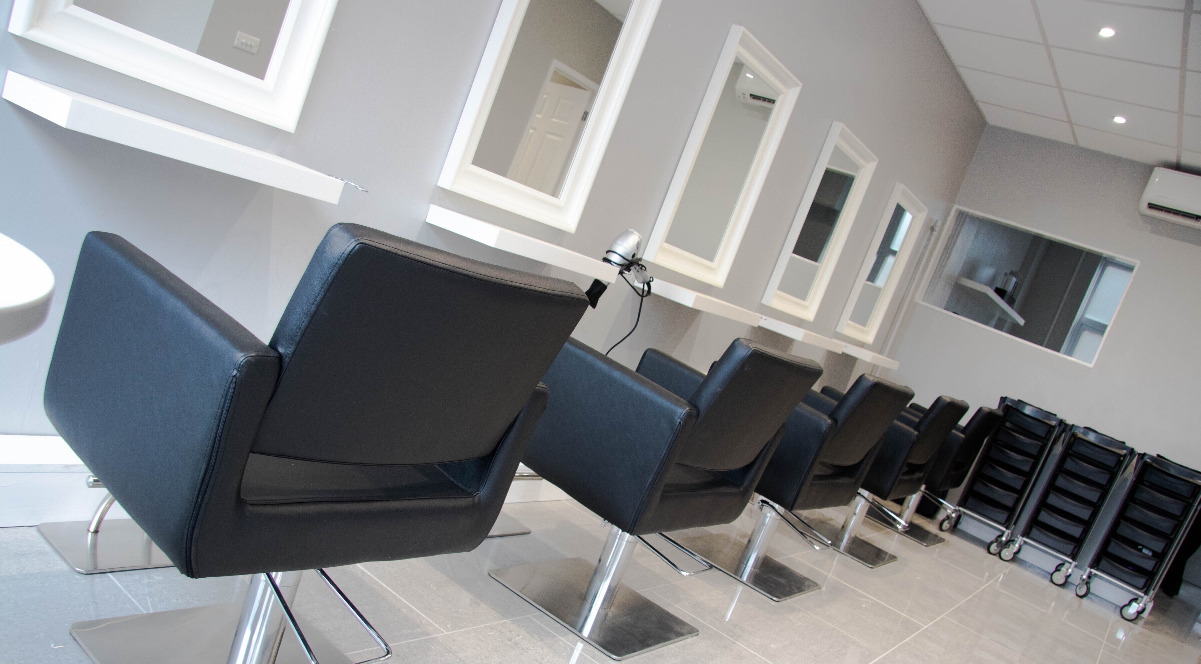 Row of stylish salon chairs at Beautique Hair and Beauty Bar, Haywards Heath, GB.