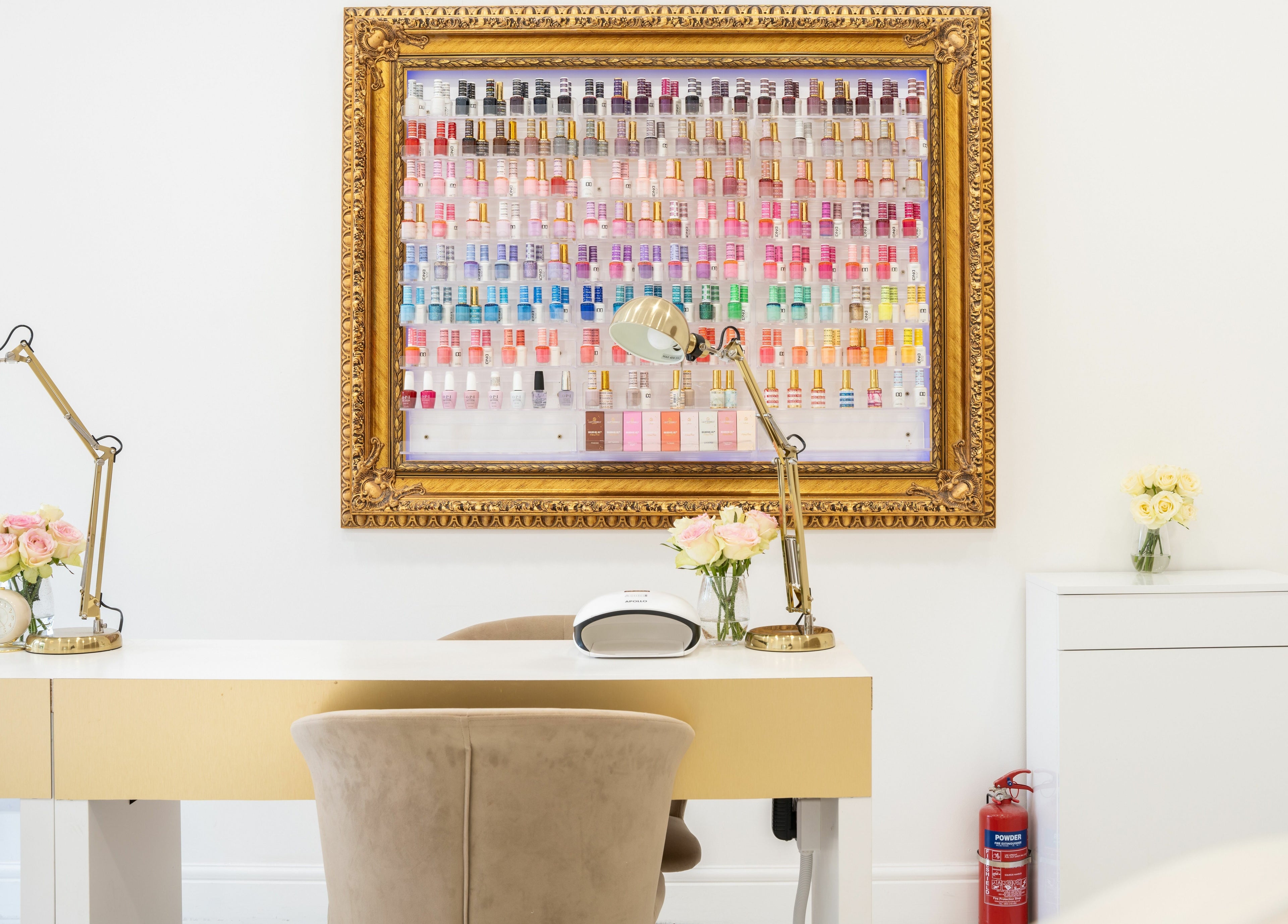 Nail polish display at Lashes by Nadia, Chessington, England, GB showcasing a vibrant array in a golden frame.