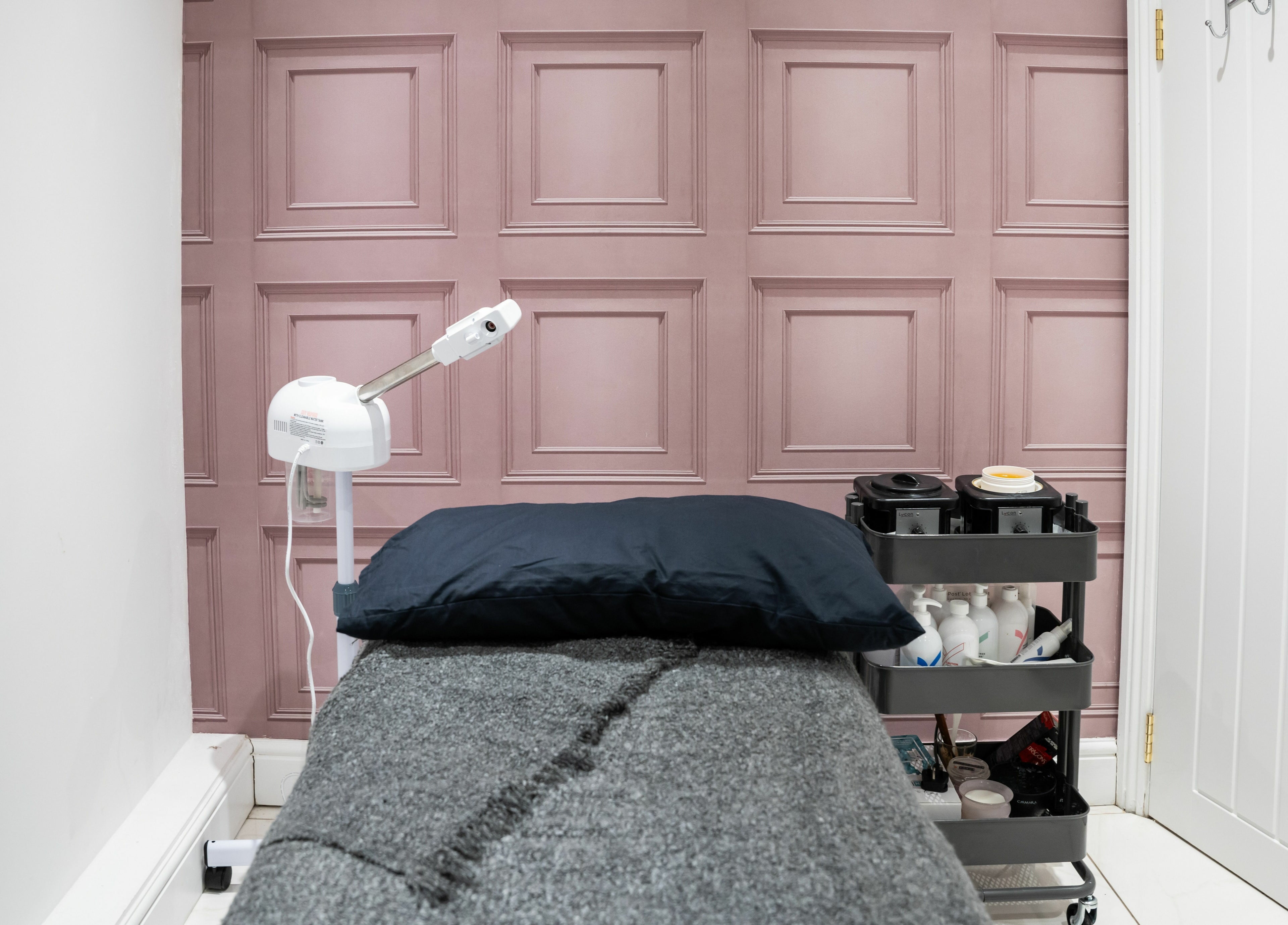 Cozy lash treatment room at Lashes by Nadia in Chessington, England, GB with a plush bed and soft pink walls.