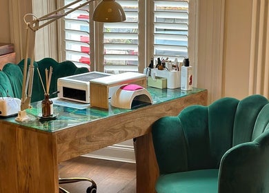 Elegant nail salon desk at Chapter1 Salon, Cheltenham, England, GB with plush chairs and nail equipment.