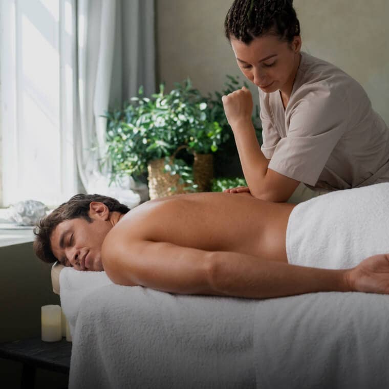 Client receiving a relaxing back massage in a spa environment, showcasing massage therapy services on Fresha.