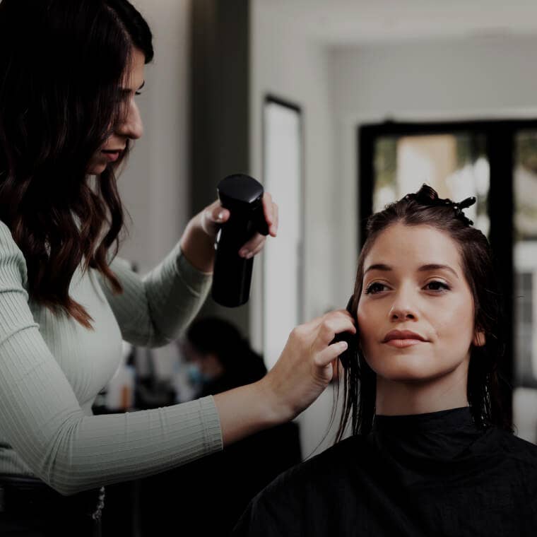 Hair stylist working on a client's hair in a chic salon, depicting salon services available on Fresha.