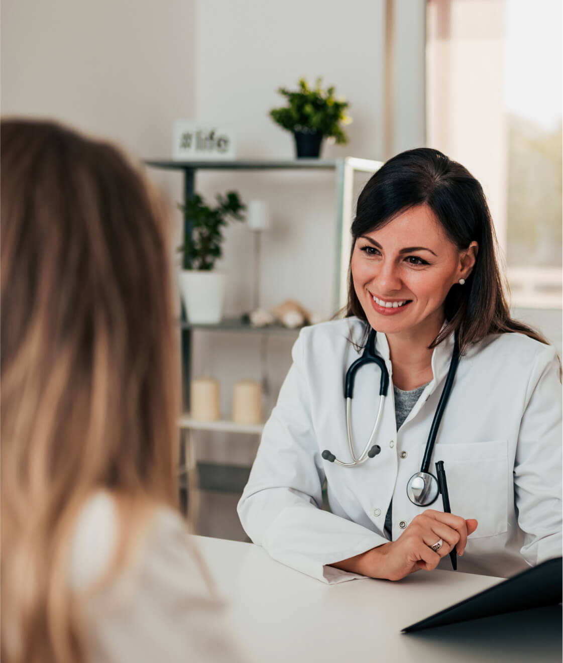 Eine medizinische Fachkraft berät eine Patientin in einem Empfangsbereich der Klinik.