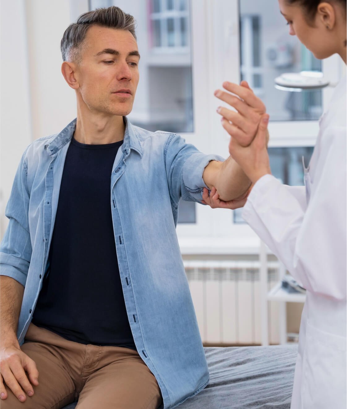 Physiotherapeut, der eine Patientin bei Dehnübungen unterstützt.