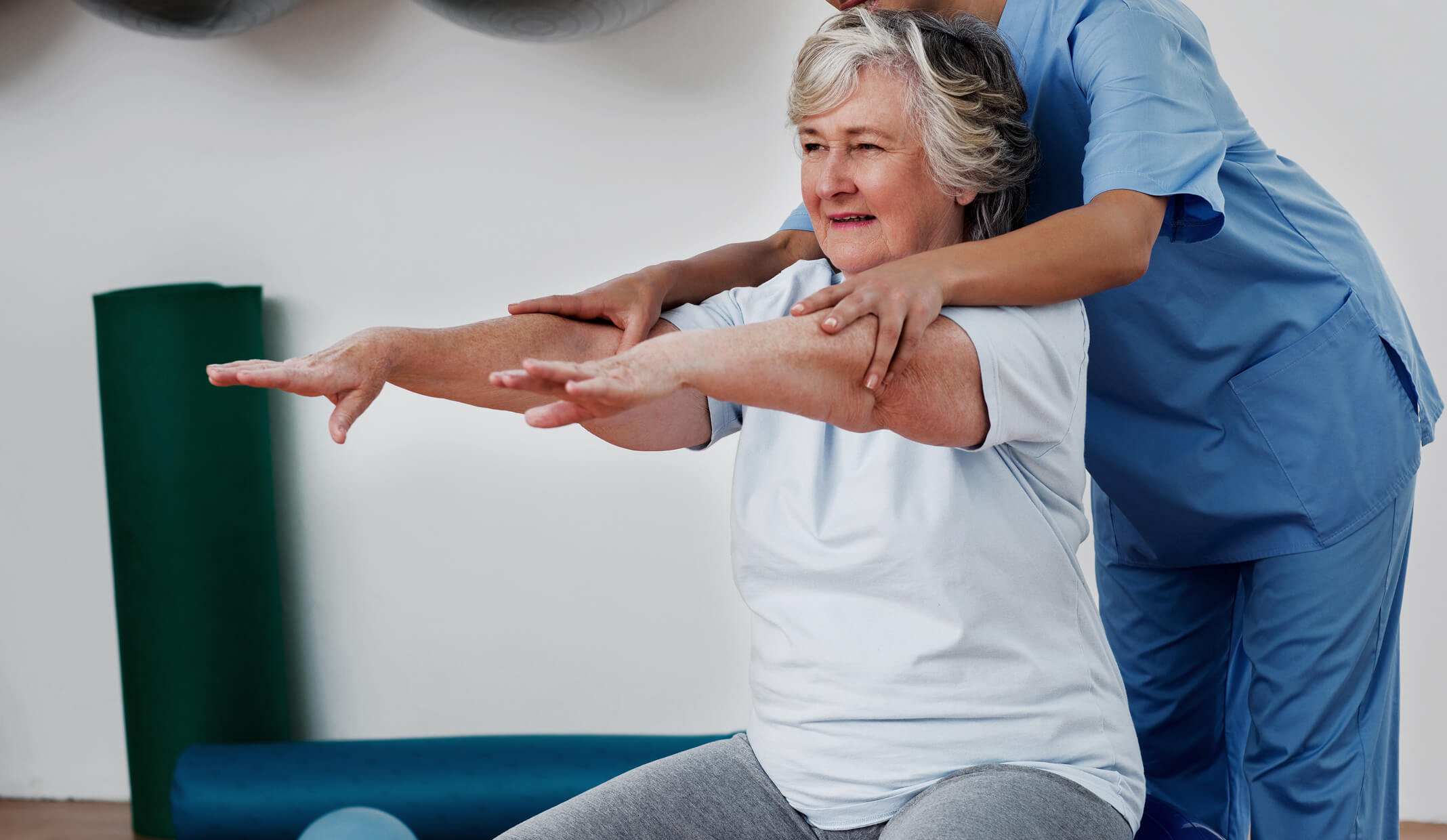 Physiotherapeut, der einen Patienten bei Übungen in einem Rehabilitationszentrum unterstützt, um Physiotherapie-Dienstleistungen auf Fresha hervorzuheben.