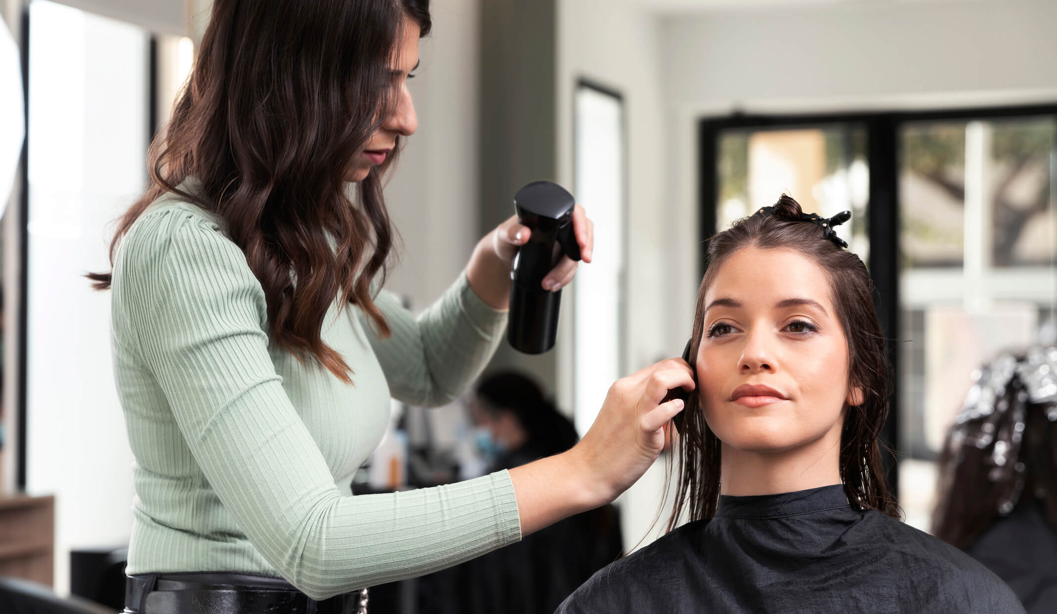 Hair stylist working on a client's hair in a chic salon, depicting salon services available on Fresha.