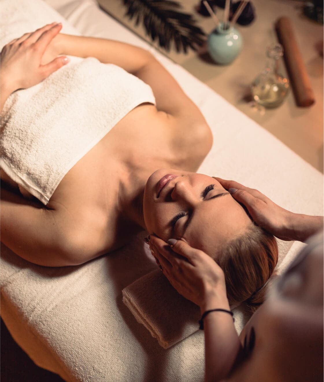 Eine Frau entspannt sich mit einer Gesichtsmaske in einem ruhigen Spa-Raum.
