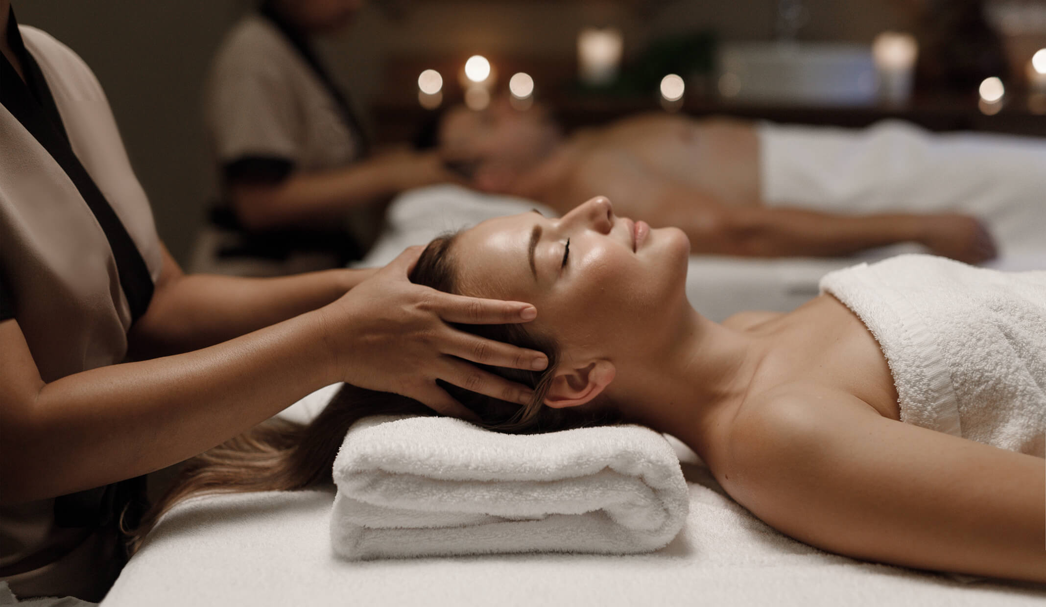 Woman relaxing in a spa with a towel wrap and facial mask, representing spa and wellness services on Fresha.