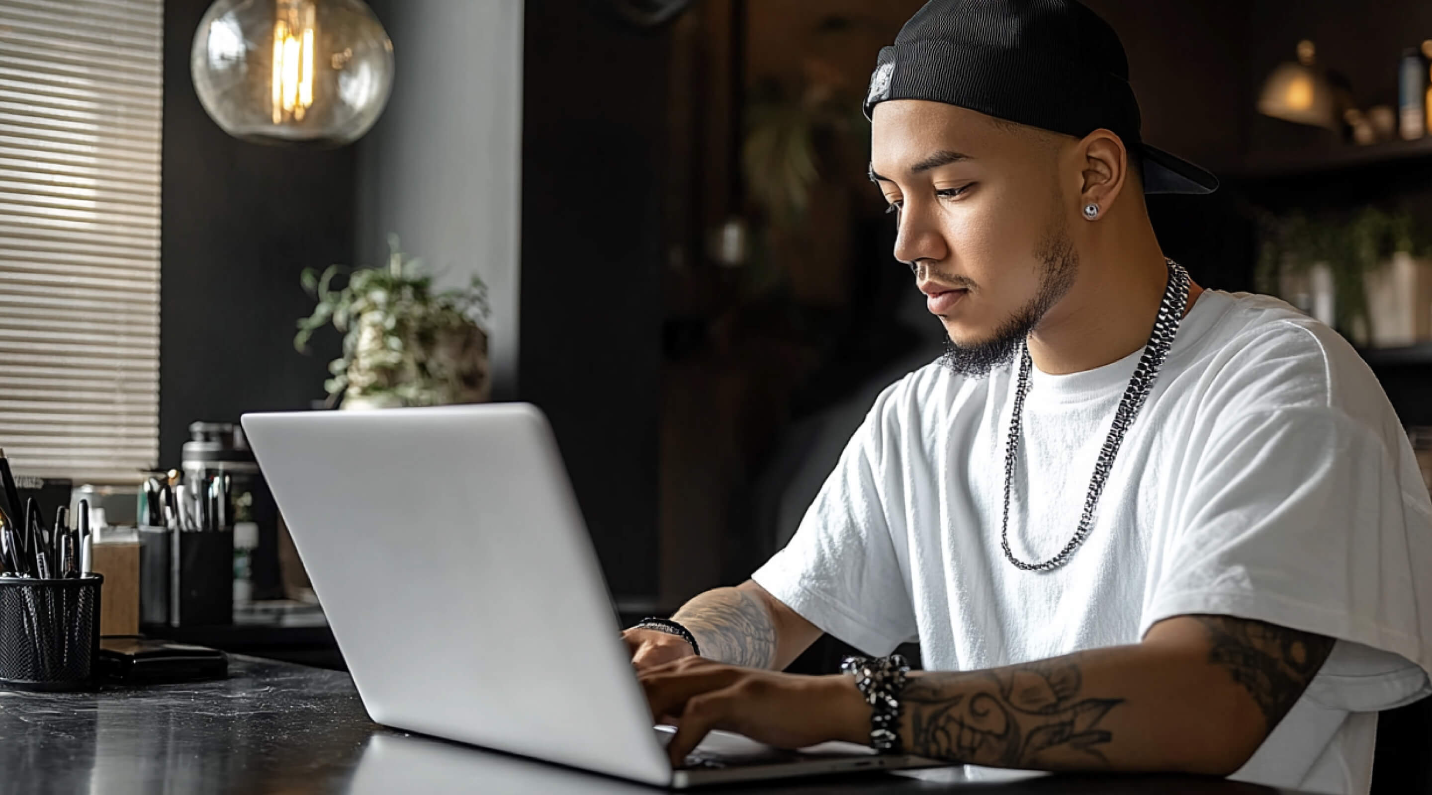 Tattoo artist focused on inking a client's arm in a well-lit studio with equipment in the background.