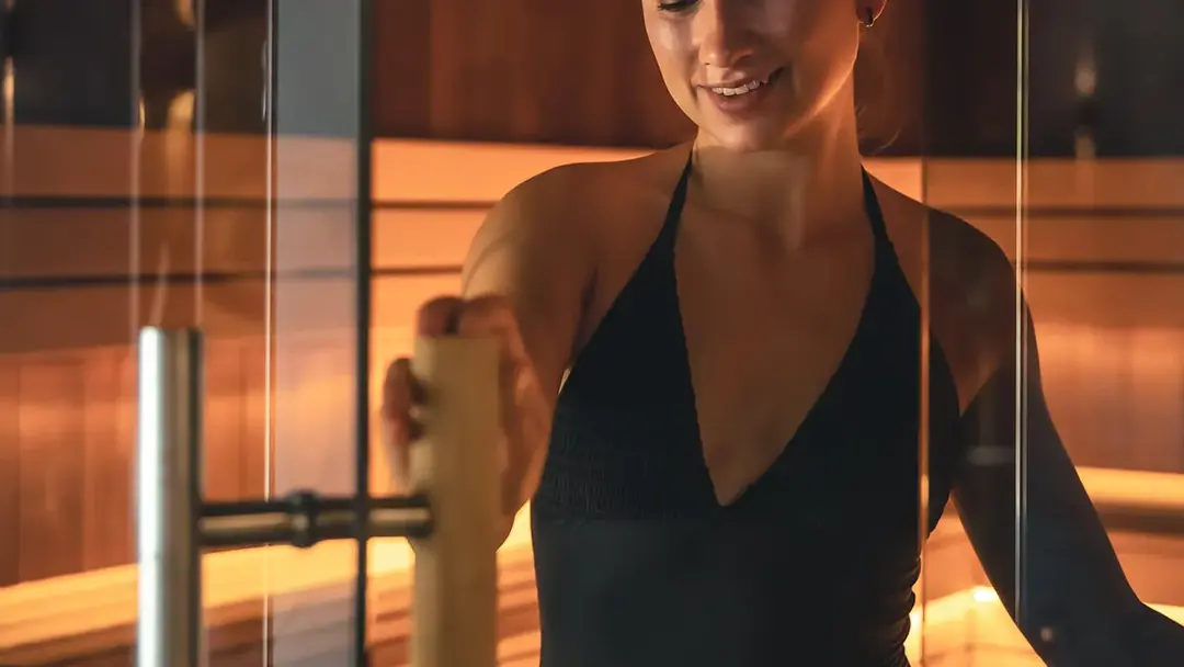 Vrouw die in een spray tan cabine staat tijdens een bruiningsessie