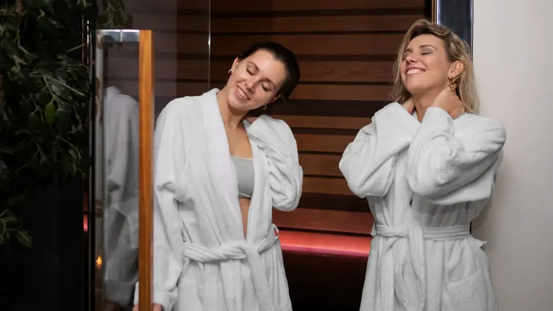 Glimlachende klant die resultaten bewondert na professionele spray tan