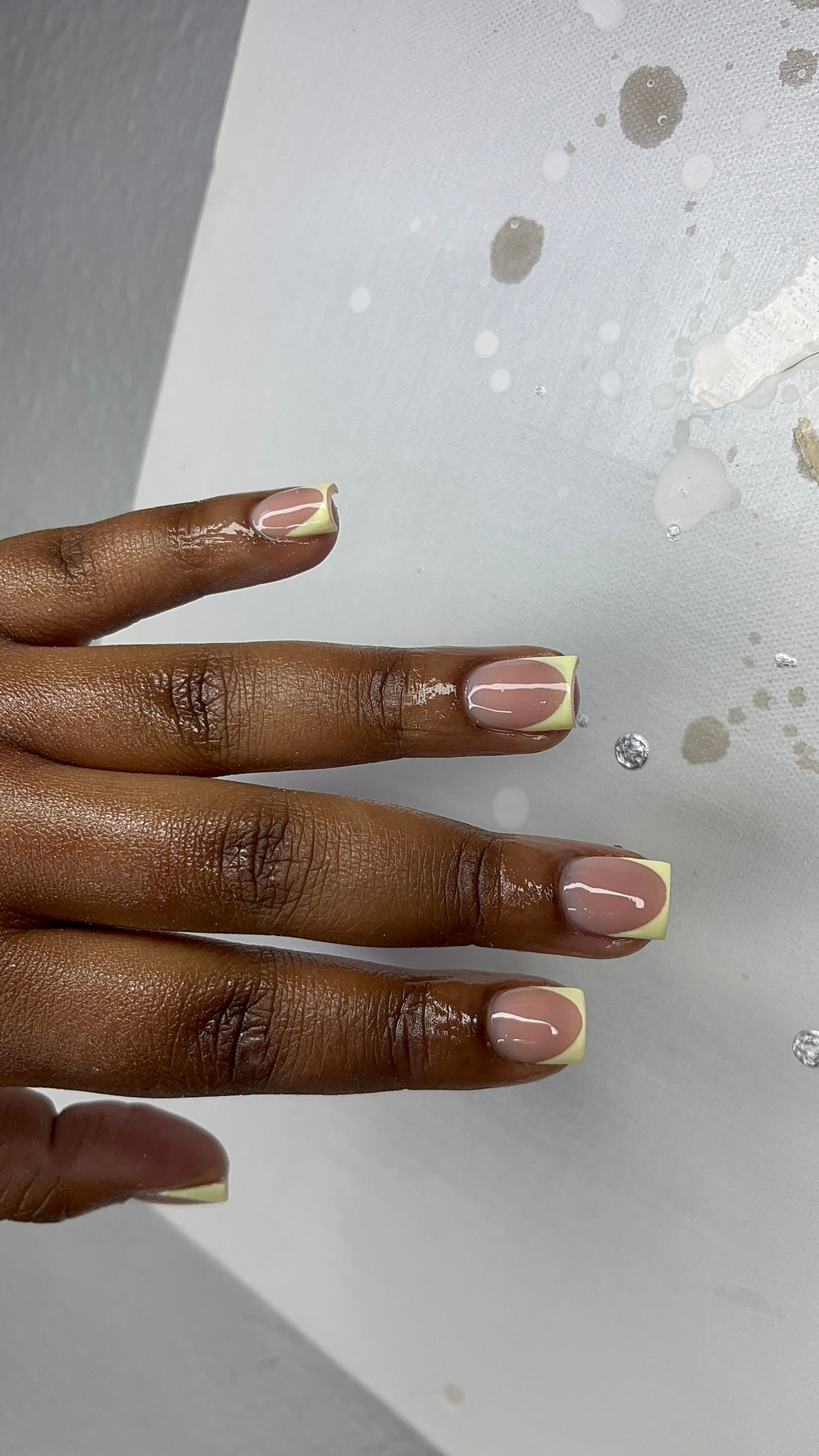 Gel nail art with a nude and yellow accent design on a hand with Ayra Classic in Krugersdorp, Gauteng, ZA.